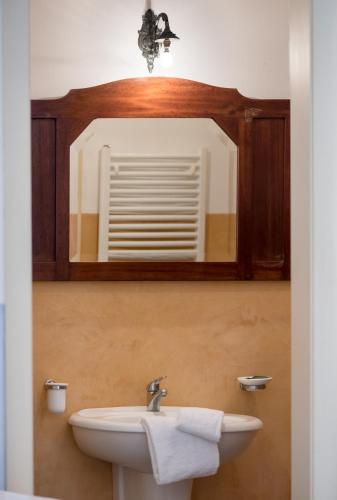 un bagno con lavandino e specchio di Palazzo Laura a Morciano di Leuca