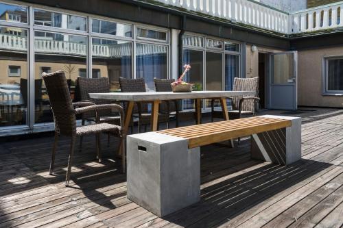 a wooden table with chairs and a bench on a deck at Teaterhotellet in Malmö