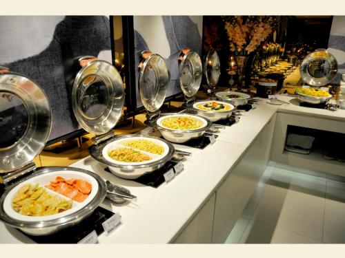 a buffet line with bowls of food on a table at Goldmet Inn Changzhi Bayi Square in Changzhi