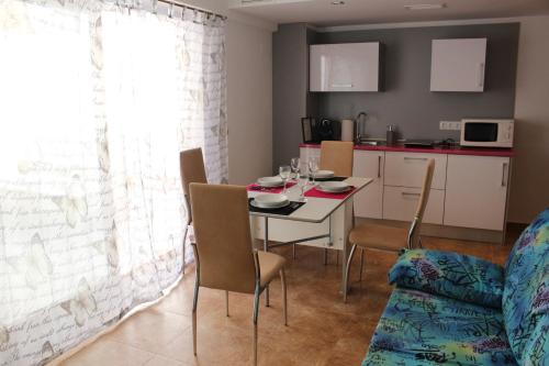 Apartamento de Silvia في أليكانتي: مطبخ وغرفة طعام مع طاولة وكراسي