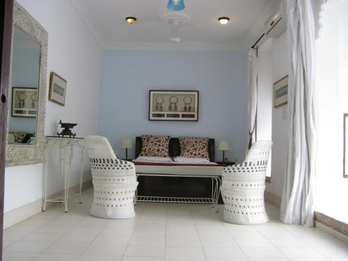 a room with two white chairs and a table at Hotel Bundi Haveli in Būndi