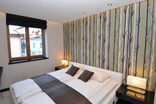 a bedroom with a large white bed with a window at Andantino by Schladmingurlaub in Schladming