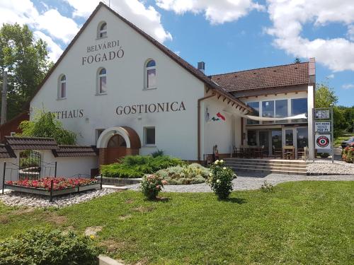 a white building with a sign on the side of it at Belvárdi Fogadó in Belvárdgyula