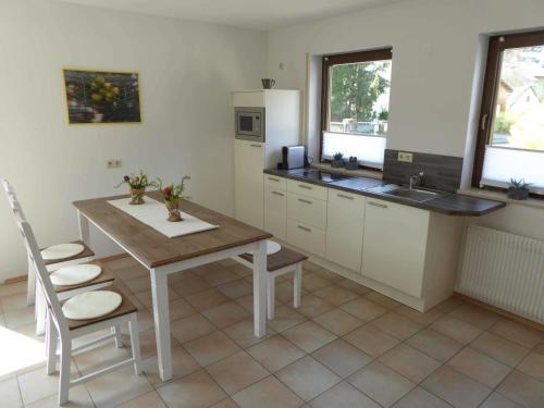 a kitchen with a wooden table and a table and chairs at Ferienwohnung naehe Freiburg FeWo in Holzhausen