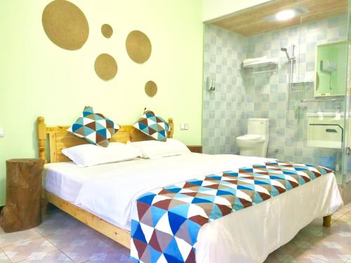 a bedroom with a large bed and a bathroom at Peace Inn The Leshan Giant Buddha Branch in Leshan