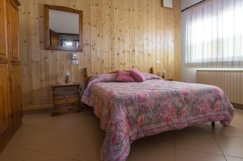 Fratta PolesineにあるDa Zio Gianni 2のベッドルーム1室(ピンクの毛布と鏡付きのベッド1台付)