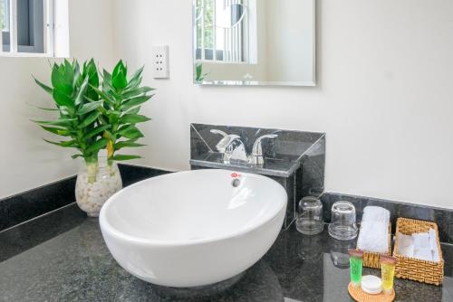 un bagno con una vasca bianca e un lavandino di Tran Family Villas Boutique Hotel a Hoi An