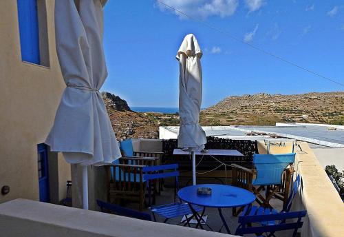 a balcony with a table and chairs and an umbrella at Chora View in Kýthira