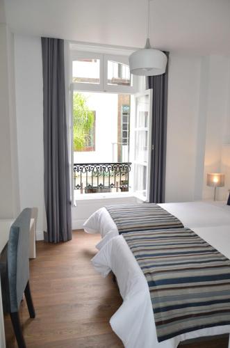 a bedroom with a large bed and a window at Edificio Charles 104 in Funchal