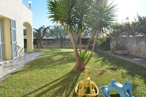 a toy train sitting in the grass next to a palm tree at Residence Villa Carmen fronte mare a 50 mt in Pietra Ligure
