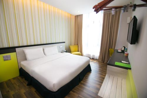a hotel room with a bed and a television at INDRA HOTEL - BOUTIQUE SUITES in Ipoh