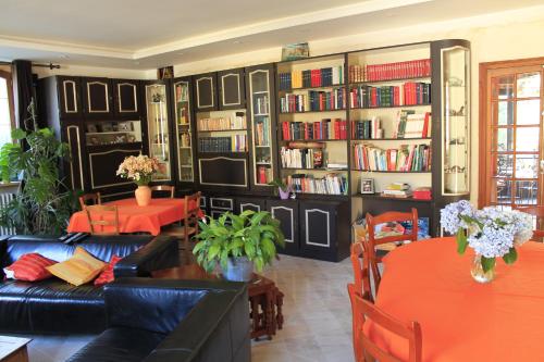 a living room with a couch and tables and book shelves at la Passerelle in Chavagnes-en-Paillers
