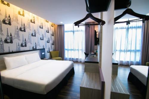 a hotel room with a bed and a desk at INDRA HOTEL - BOUTIQUE SUITES in Ipoh