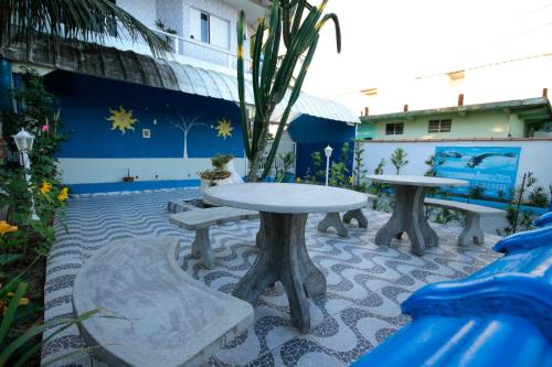 a group of tables and chairs in a patio at Apartamentos Águia Suíte casal 2 in Ilha Comprida