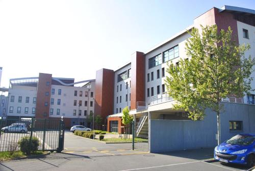 a car parked in a parking lot in front of a building at Auberge de jeunesse L'Escale in Dunkerque