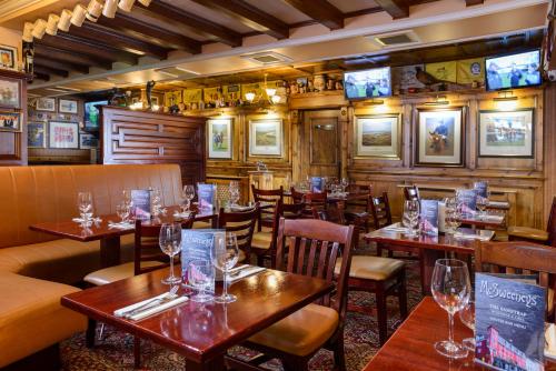 un restaurante con mesas y sillas y copas de vino en McSweeney Arms Hotel, en Killarney