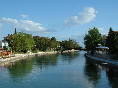 a view of a river with a bridge in the background at Hotel Ambasador Garden in Lezhë