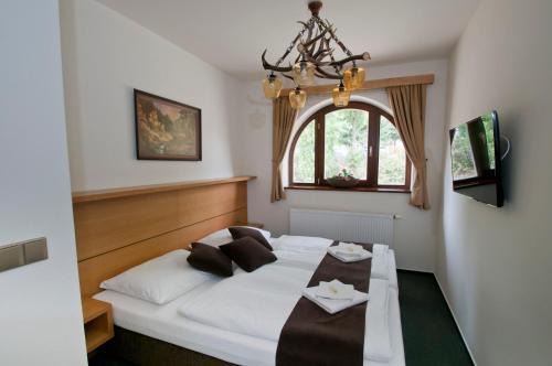 Postel nebo postele na pokoji v ubytování Hotel resort Lovecká bašta Strakonice