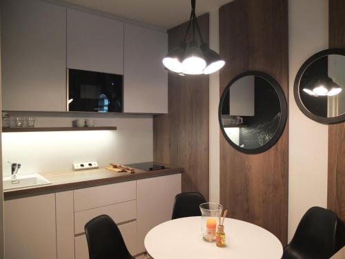 cocina con mesa, sillas y espejo en Sun Valley Apartment, en Bad Hofgastein