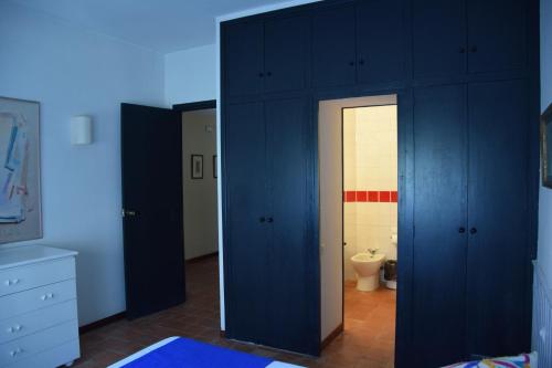 a bathroom with blue cabinets and a toilet at Apartamentos Les Barbes in Caldes d'Estrac