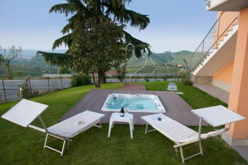 a backyard with a pool and two chairs and a table at Intera casa con due appartamenti indipendenti e vasca idromassaggio a Barbaresco, Langhe in Barbaresco