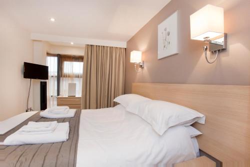 a hotel room with a bed with two towels on it at Saint Georges Keep in York