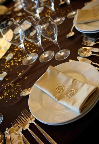 a plate with a napkin on a table with wine glasses at Quinta do Medronheiro Hotel Rural in Viseu