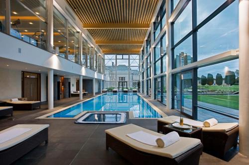 a large room with a large pool and a large window at Castlemartyr Resort Hotel in Cork