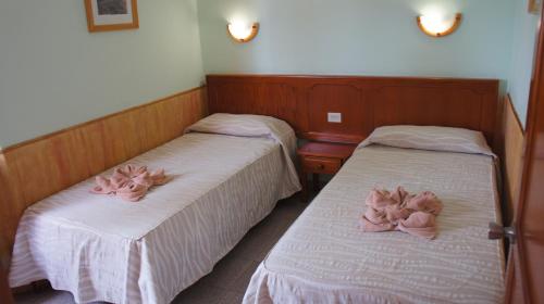 カレタ・デ・フステにあるCastillo Playaのピンクの人形が飾られたベッド2台が備わる客室です。