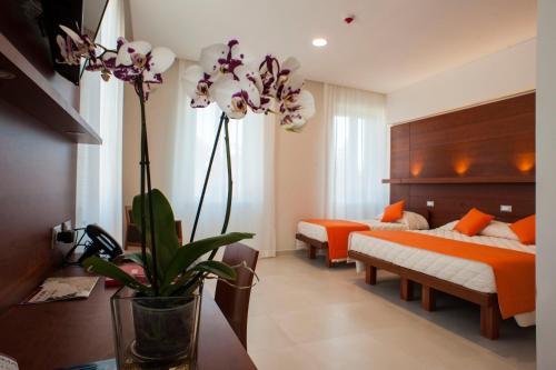 1 dormitorio con 2 camas y un jarrón con flores en Villa Angelina en Roma