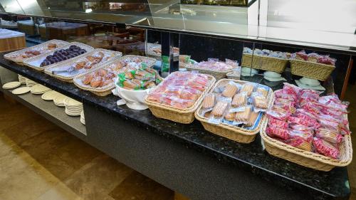 a counter with many baskets of food on it at Hotel Avenida in Benidorm