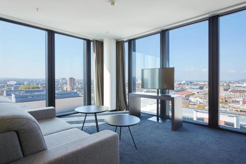 a living room filled with furniture and a view of the ocean at Hyperion Hotel Basel in Basel