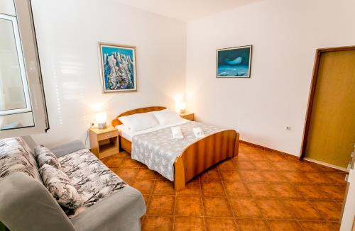 a bedroom with a bed and a couch in it at Apartments Batricevic in Herceg-Novi