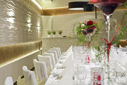 a dining room with white tables and white chairs at Hotel Stara Kamienica in Piekary Śląskie
