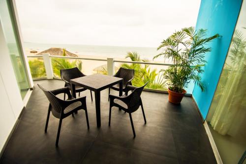 a table and chairs on a balcony with the beach at Nauti-k Beach Hotel in Tumbes