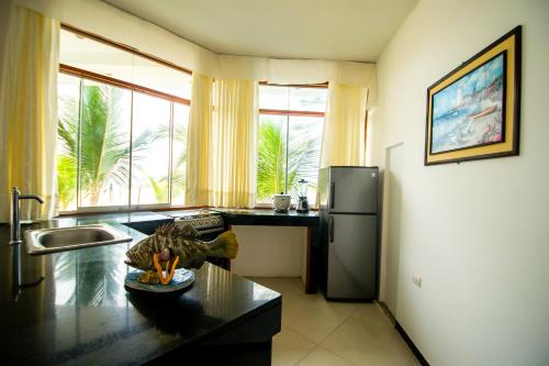 a kitchen with a stainless steel refrigerator and a table at Nauti-k Beach Hotel in Tumbes