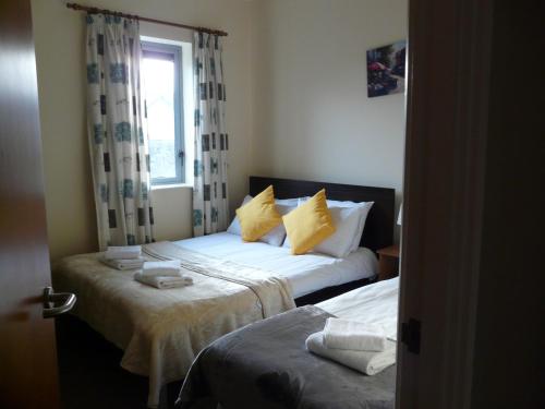 a bedroom with two beds and a window at The Courtyard Apartments in Carrick on Shannon