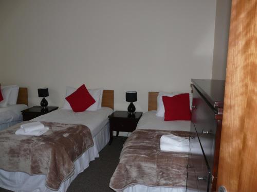 a hotel room with two beds with red pillows at The Courtyard Apartments in Carrick on Shannon