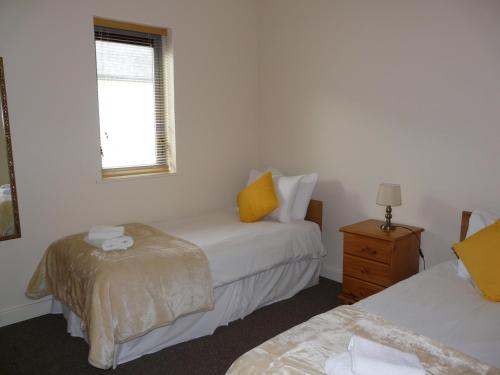 a bedroom with two beds and a window at The Courtyard Apartments in Carrick on Shannon