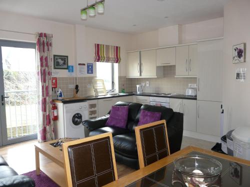a living room with a couch and a kitchen at The Courtyard Apartments in Carrick on Shannon