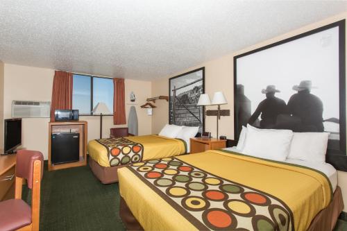 a hotel room with two beds and a television at Super 8 by Wyndham Casper West by the River in Casper