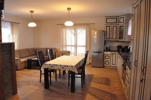 a kitchen and dining room with a table and chairs at Zakątek Lupkowski in Łupków