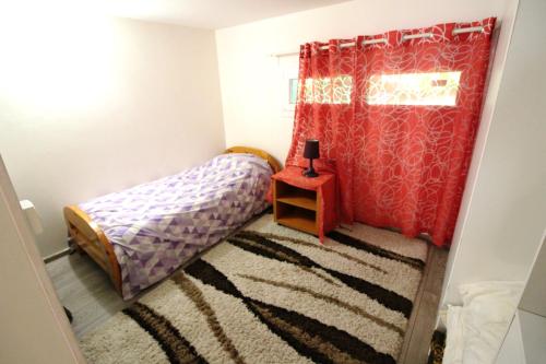 サン・ジェルマン・アン・レーにあるAppartement Attarkiの小さなベッドルーム(ベッド1台、赤いカーテン付)