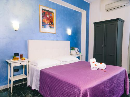 um quarto com uma cama com um cobertor roxo em Diana Inn Accommodations em Pompeia