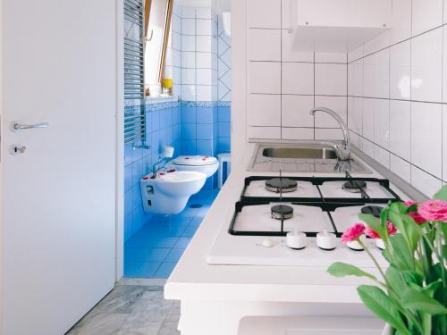a blue and white kitchen with a stove in it at Diana Inn Accommodations in Pompei