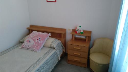ペニスコラにあるAlpen 1 Bungalow Peñismar Iの小さなベッドルーム(ベッド1台、椅子付)