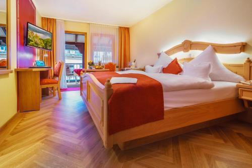 a bedroom with a large bed with a red blanket at Altkölnischer Hof in Bacharach