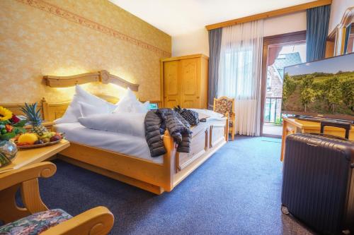 a bedroom with a bed and a desk and a television at Altkölnischer Hof in Bacharach