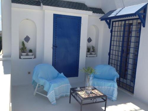 a room with two blue chairs and a table at Appartement - Vue sur Mer- Hammamet in Hammamet