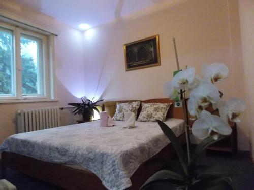 een slaapkamer met een bed met witte lakens en bloemen bij Boeritza Hotel Complex in Vladaya